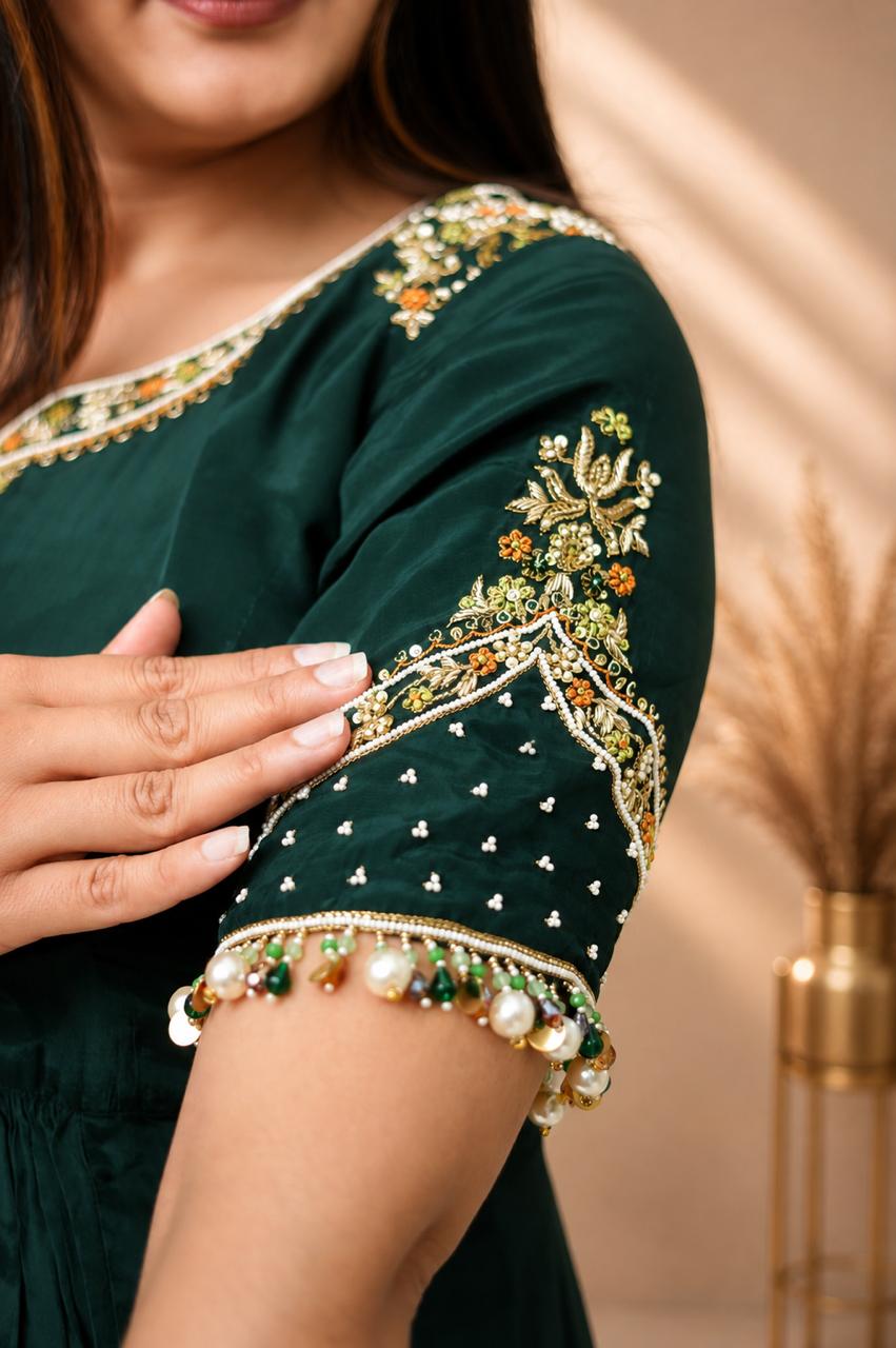 Close-up of emerald green Anarkali kurta sleeve with gold embroidery