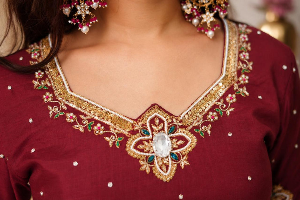 Close-up of gold embroidered neckline on wine maroon Anarkali suit