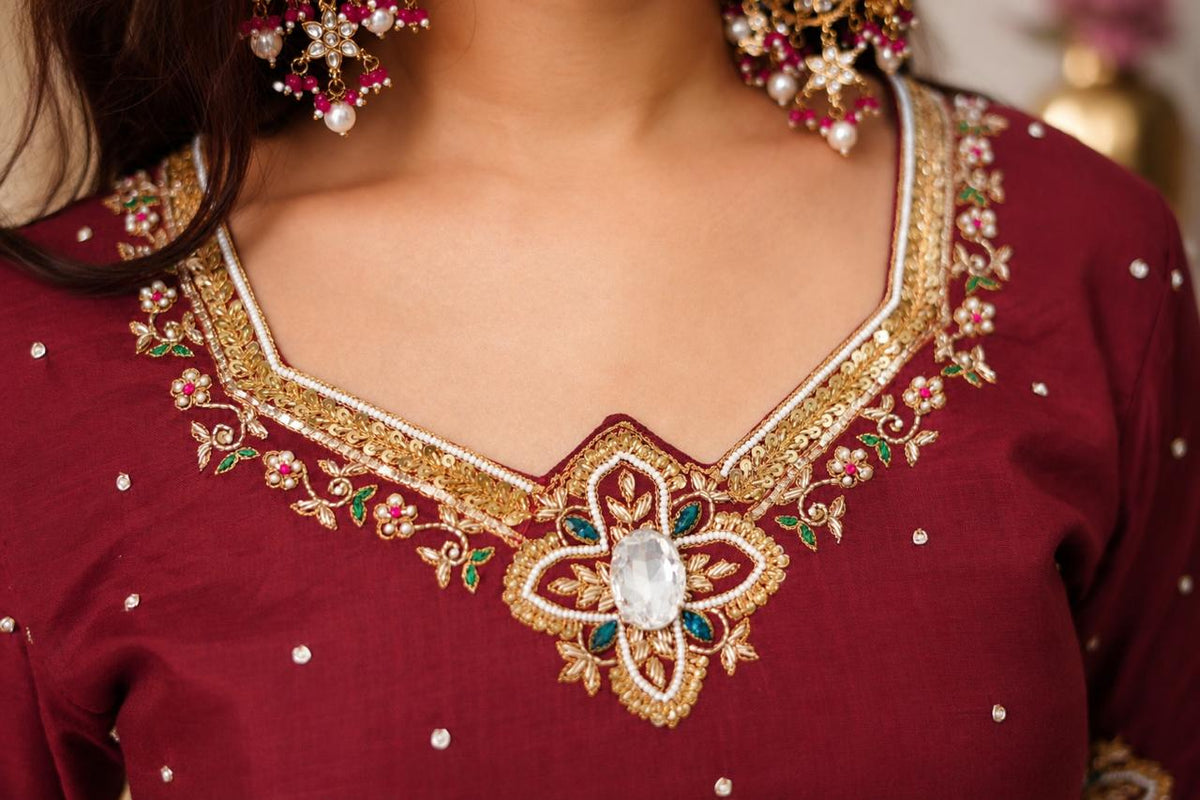 Close-up of gold embroidered neckline on wine maroon Anarkali suit