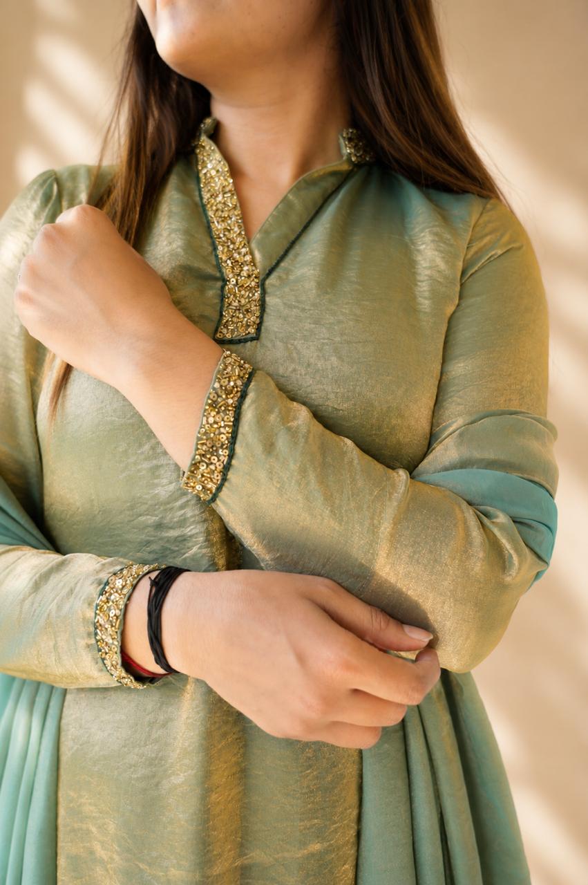 Close-up of sage green kurta with gold embroidered neckline and cuffs