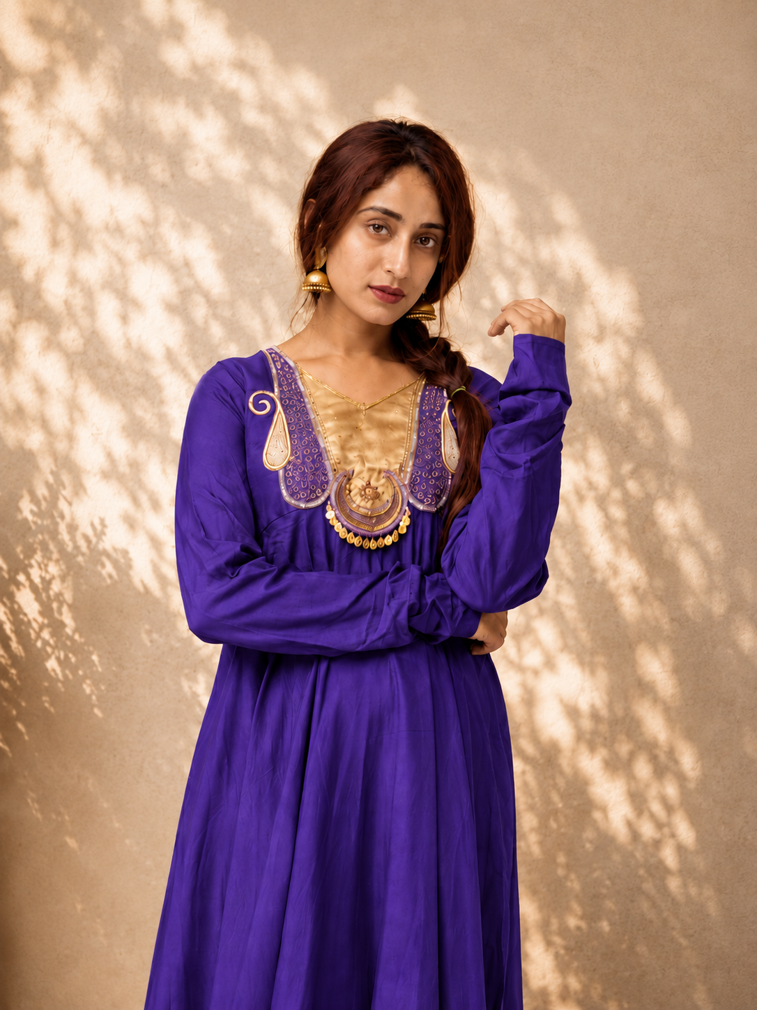 Close-up of royal purple Anarkali kurta with detailed gold embroidered neckline